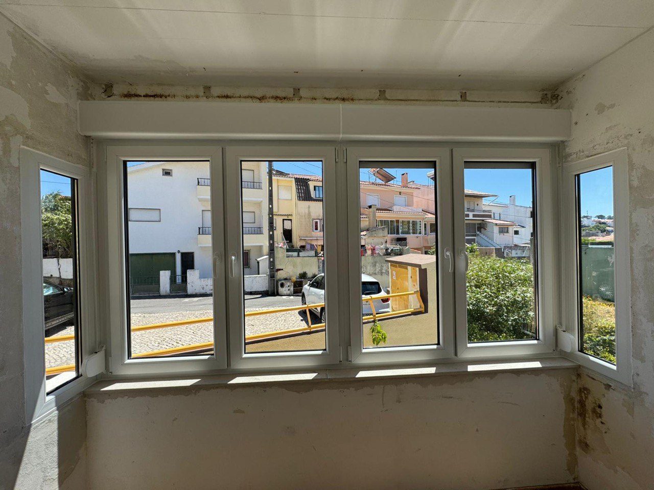 Bow window com cinco folhas em PVC branco e folhas laterais, durante a renovação