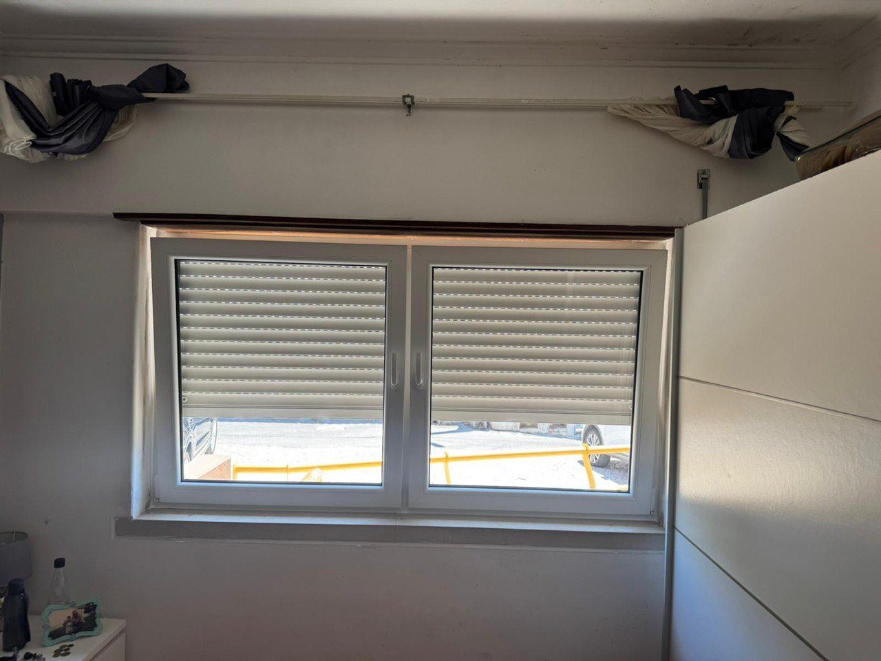 Janela de duas folhas em PVC branco com estore exterior meio descido