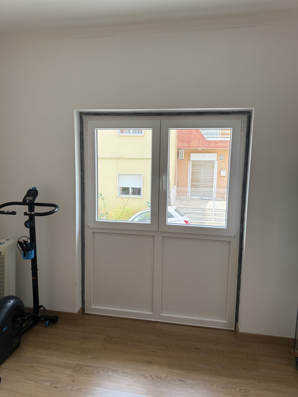 Porta-janela de duas folhas em PVC branco com painéis opacos em baixo