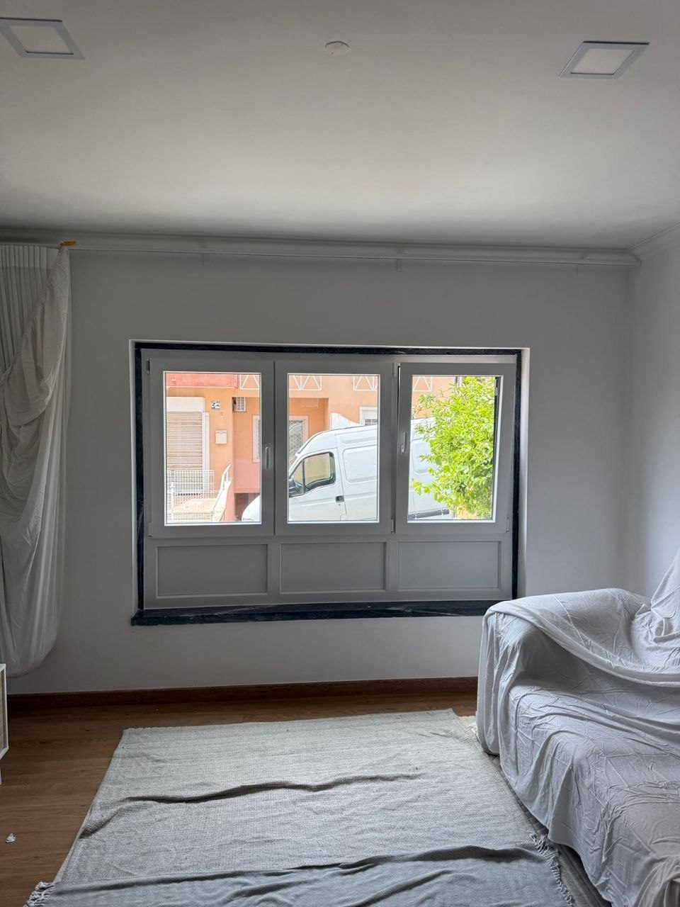 Conjunto de três folhas com painéis inferiores numa sala em renovação